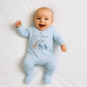 A toddler is wearing a Be Kind Little World Sleepsuit