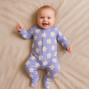 A toddler is wearing a Bloom and Dream Sleepsuit