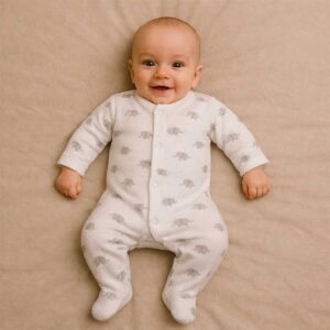 A toddler is wearing a little elephant whisper sleepsuit