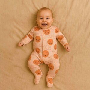 A toddler is wearing a Sunny Smiles Sleepsuit