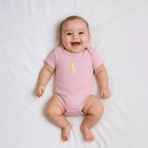 A toddler is wearing a Tiny Giraffe Charm Baby Bodysuit