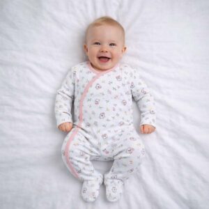 A toddler is wearing a Blossom Kitty Sleepsuit