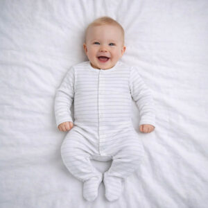 A toddler is wearing a Classic Cloud Stripe Sleepsuit