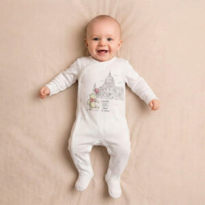 A toddler is wearing a Little Big Moment Sleepsuit