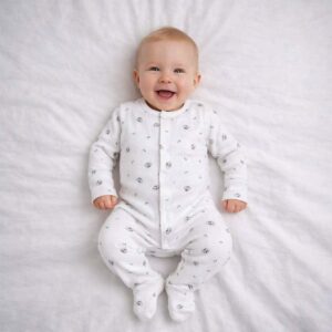 A toddler is wearing a Little Koala Cuddles Sleepsuit