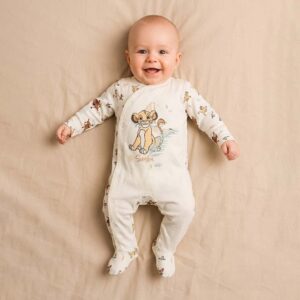 A toddler is wearing a Little Lion Cub Sleepsuit