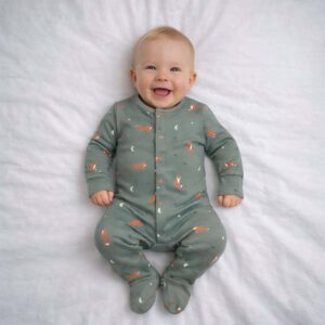 A toddler is wearing a Moonlit Fox Dreams Sleepsuit