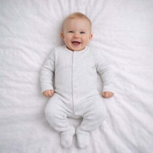 A toddler is wearing a Soft Cloud Grey Sleepsuit