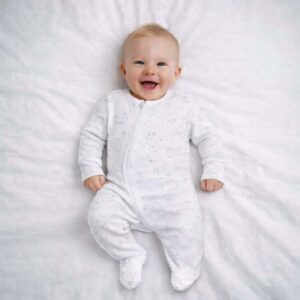 A toddler is wearing a Daddys Brightest Star Sleepsuit