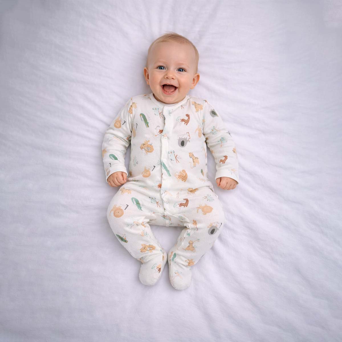 Baby wearing a baby animal print sleepsuit with playful animal illustrations