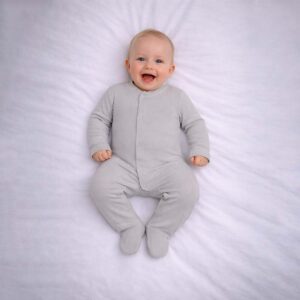 Baby wearing a baby grey sleepsuit with soft fabric and minimal design