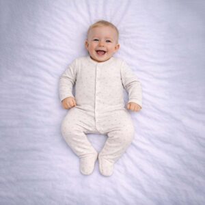 Baby polka dot sleepsuit in cream with a soft all-over dot pattern