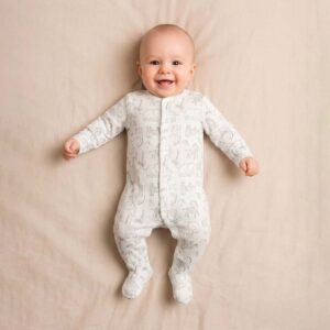 Baby wearing a baby safari animal sleepsuit with soft cream fabric and animal illustrations