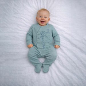Baby wearing a baby tiger print sleepsuit with soft green fabric and playful tiger design