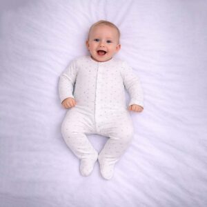 Blue dot baby sleepsuit worn by baby showing soft white fabric with blue dot pattern