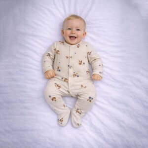 Botanical berry baby sleepsuit worn by baby showing delicate berry and leaf print