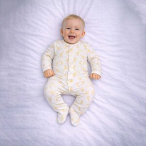 Duck print baby sleepsuit worn by baby showing cute yellow duck pattern