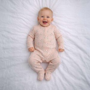 Pink floral baby sleepsuit worn by baby showing delicate floral pattern