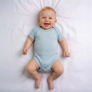Sage polka dot baby bodysuit worn by a baby during everyday wear