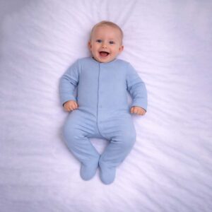 Solid blue baby sleepsuit worn by baby showing soft fabric and classic design