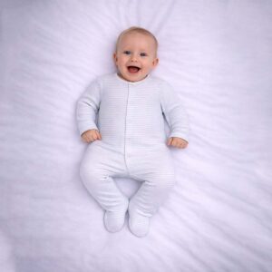 Striped baby sleepsuit worn by baby showing soft neutral striped design