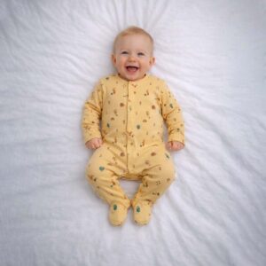 Woodland print baby sleepsuit worn by baby showing cute animals and nature design