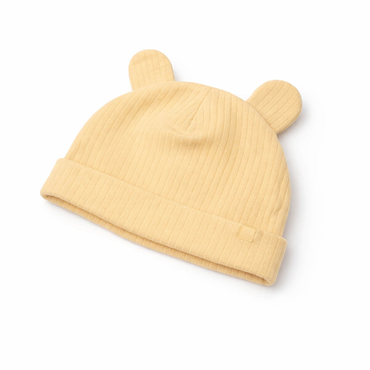 Soft yellow newborn hat with ribbed texture in studio flat lay